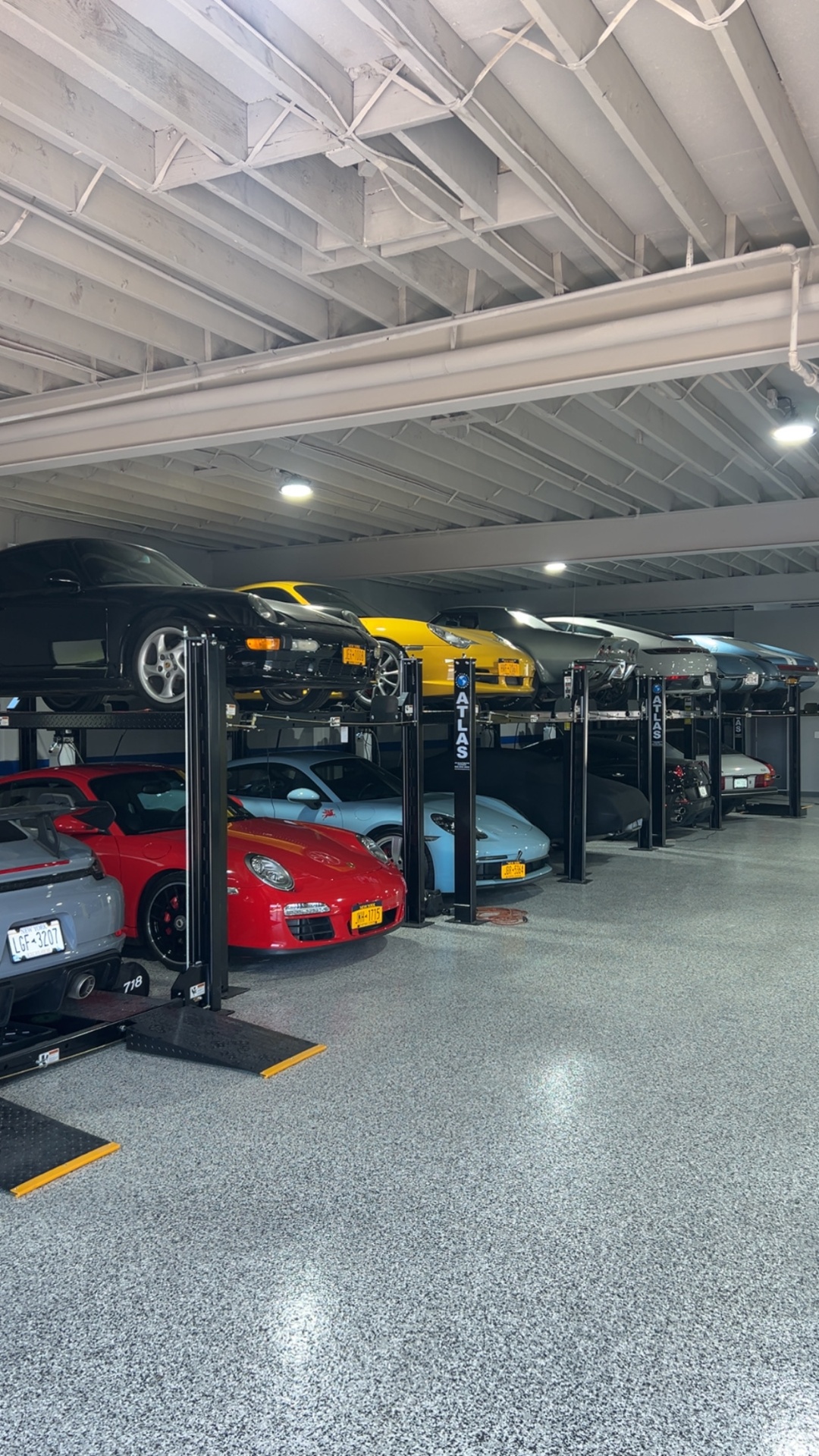 Row of Atlas four-post storage lifts with Porsches stacked above and below